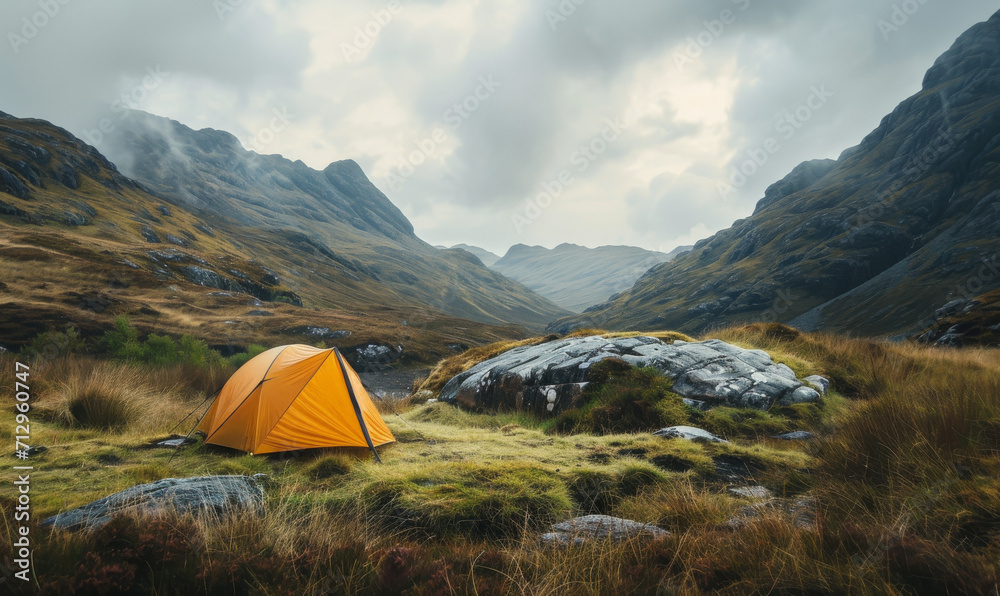 Orange tent in the Scottish Highlands basking in the sunrise glow.