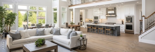 Beautiful and large living room interior with hardwood floors and vaulted ceiling in new luxury home. View of Kitchen, entryway, and second story loft style area