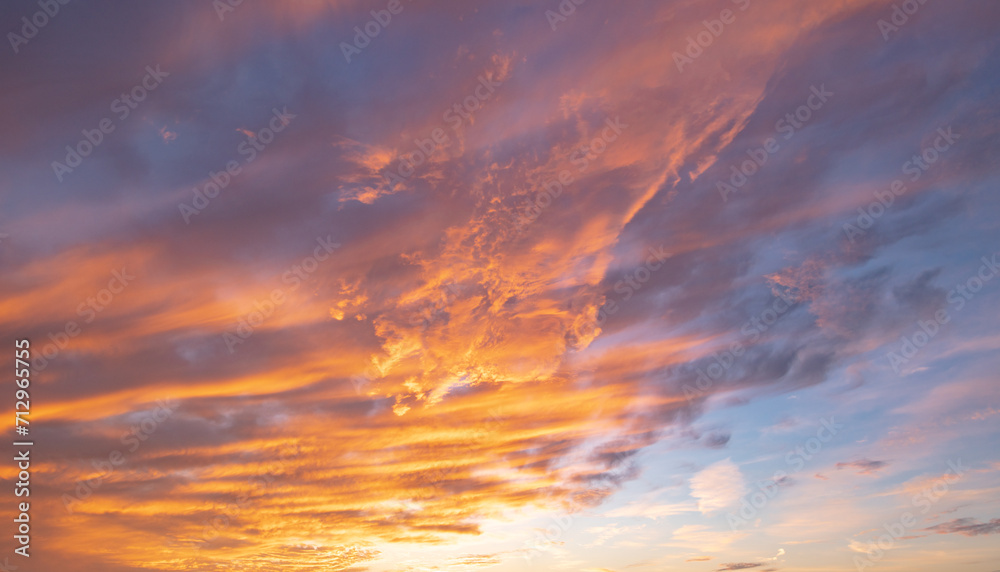 Sunrise background. Dramatic majestic scenery sunset. Sky with clouds in Sunrise sky light background. Sunrise with clouds in various shapes. Calm Sunrise sky and sun through clouds over.