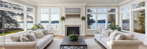 Beautiful living room interior with hardwood floors and fireplace in new luxury home. Large bank of windows hints at exterior view