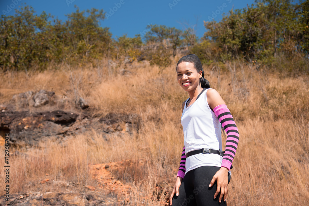 Portrait of Happy beautiful african American woman runner smiling after exercising, Healthy female living confidently and outdoors fitness. Fitness woman taking a break after running workout.