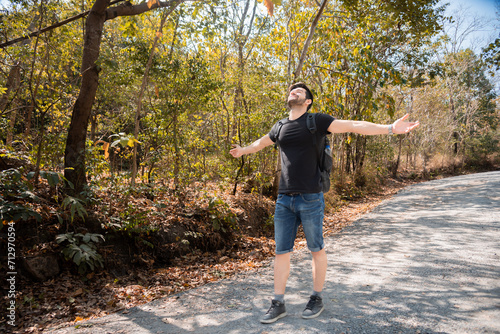 Caucasian man enjoying nature amidst mountains and trees during the weekend. Happy man spends his free time hiking, walking, exploring, adventure in forest beautiful autumn day. #712970594