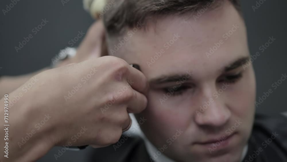 Hair clipper cutting the head of a handsome caucasian male client in a hair salon, close-up. Modern and stylish haircuts in the barbershop. Slow motion Hair clipper cutting the head of a handsome caucasian male client in a hair salon, close-up. Modern and stylish haircuts in the barbershop. Slow motion
