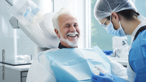 Elderly male patient with white hair is smiling and sitting in a dental chair