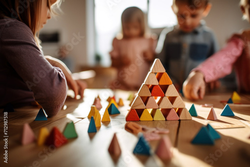 Children engage in play with colorful wooden blocks, building a pyramid structure on a table in the kindergarten