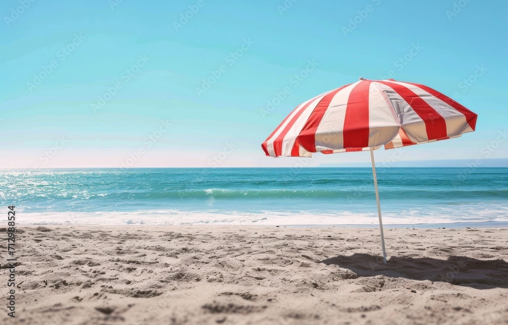 an outdoor red and white striped umbrella on a beach