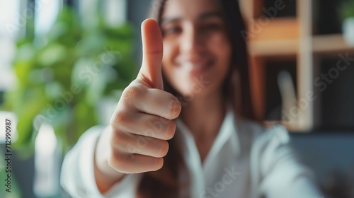 Thumbs up, blurred and working woman does agree by doing hand gesture to express she is happy. Employee likes and smiles about good news about reaching best professional career goal at work. photo