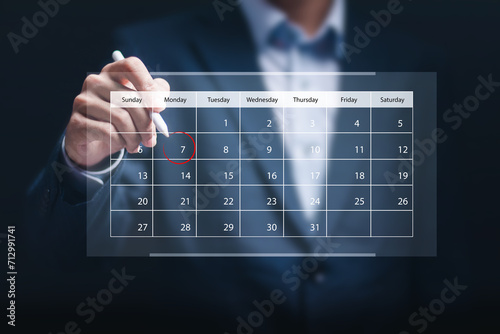 Businessman manage time on virtual screen of calendar for effective work. Highlight appointment reminders and meeting agenda on the calendar. Time management concept.