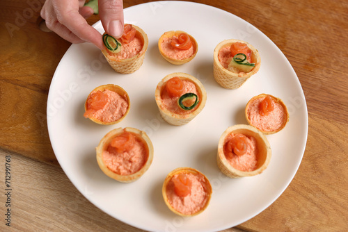 Waffle baskets with pate add salmon and cucumber. Preparation of fish canaps photo