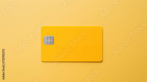 Yellow credit card placed on a flat surface with a minimalist backdrop.