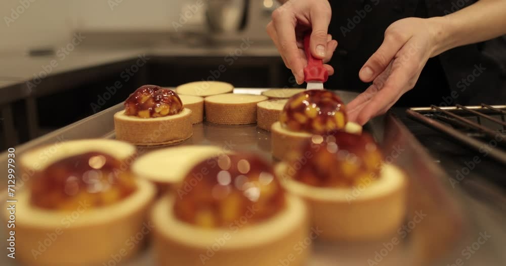 Tartlets on the table of a professional confectioner are decorated with apple-jelly filling. Tartlets on the table of a professional confectioner are decorated with apple-jelly filling.