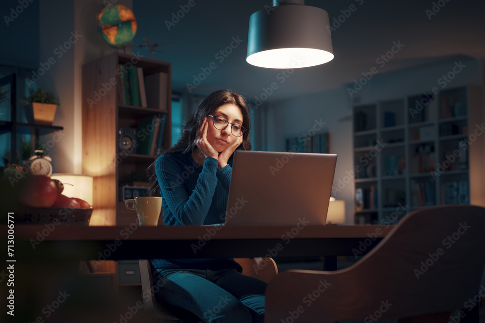 Young woman working with her laptop at night Young woman working with her laptop at night