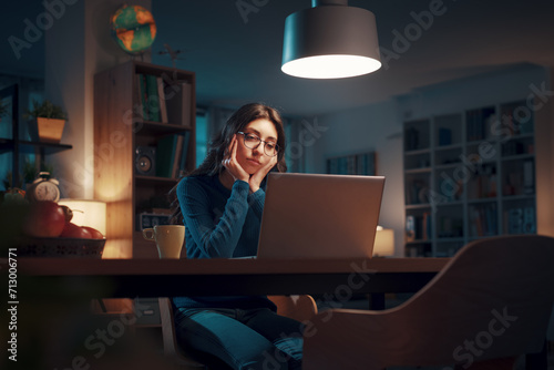 Young woman working with her laptop at night