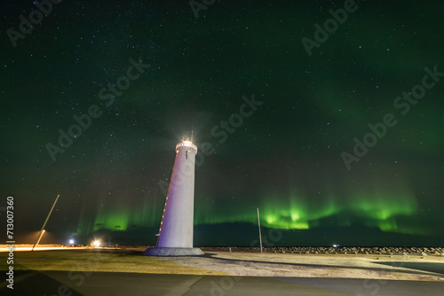 Northern Lights over Keflavik Lighthouse in Iceland with green and purple colors