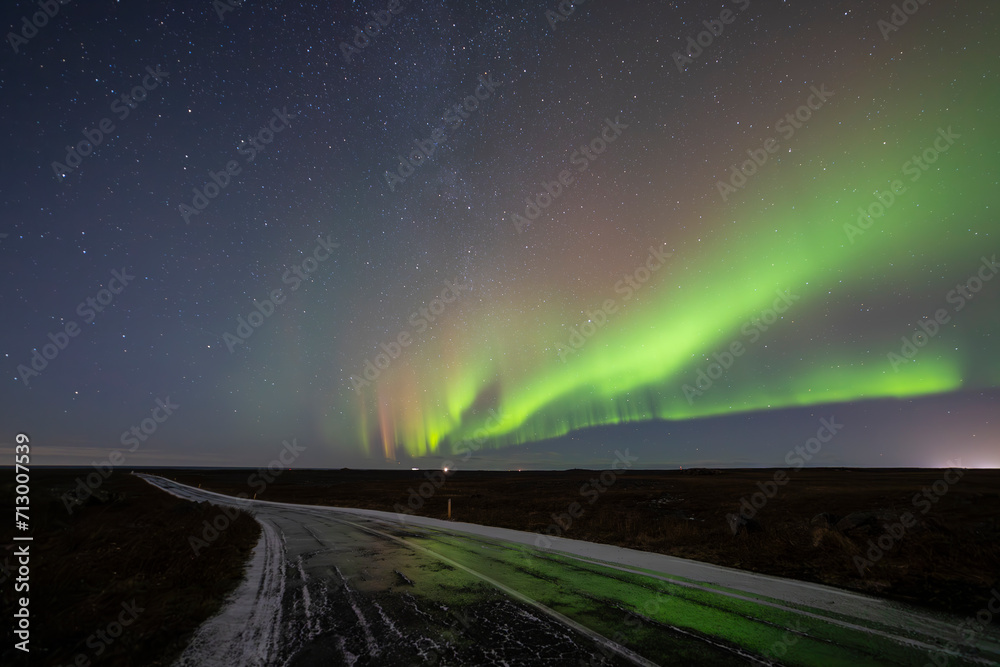 Northern Lights over Keflavik area in Iceland with green and purple colors