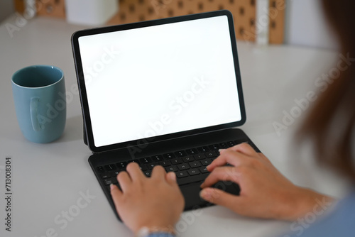 Closeup young woman working with digital tablet at home. Empty screen for advertising text