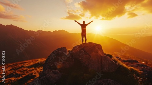 Man with arms outstretched on mountaintop