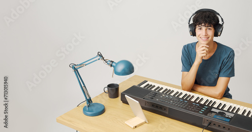 Adolescent playing the keyboard at home