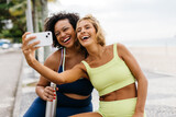 Fitness friends taking workout selfies on the promenade together