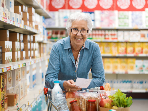 Happy senior woman buying groceries at the store