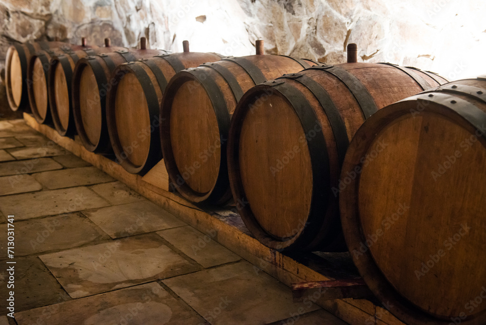 Wooden wine barrels for storage in wine cellar Wooden wine barrels for storage in wine cellar