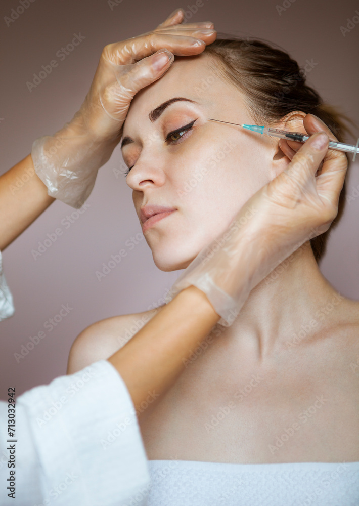 Young pretty woman getting cosmetic injection in the face like a part of the clinic treatment Young pretty woman getting cosmetic injection in the face like a part of the clinic treatment