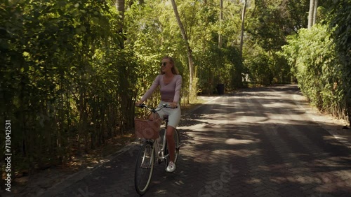 Wallpaper Mural Happy blonde haired woman riding a bicycle on a resort island in Maldives, slow motion summer view Torontodigital.ca
