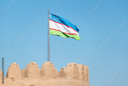 Top side of walls of Ichan-Kala fortress historical inner city and the national flag of Uzbekistan over the city. Impressive walk on the citadel wall. Khiva Xiva , Uzbekistan