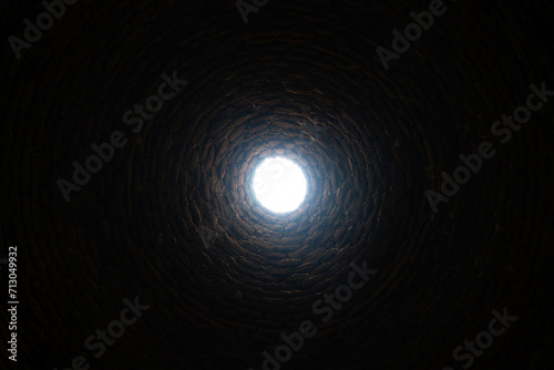 The light at the end of the tunnel concept. The old deep abandoned well. Inside view.