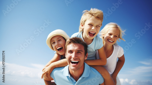 Portrait of happy family having fun on the beach against blue sky