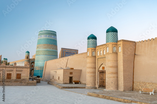 View to the unfinished Kalta Minor Minaret with Blue Mosaic Walls, which is built by Mohammed Amin Khan, in Khiva, Uzbekistan. empty streets of the ancient city of the Khorezm kingdom during the day. photo
