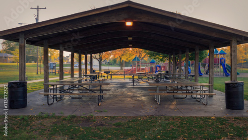 picnic tables in a pavilion are ready for the days gatherings on this summer morning