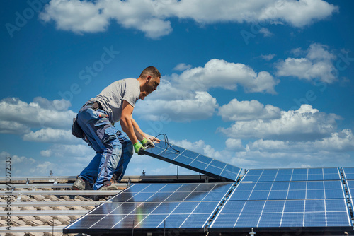 Installing solar photovoltaic panel system. Solar panel technician installing solar panels on roof. Alternative energy ecological concept. © mmphoto