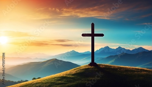 Silhouette of a christian cross on a hill in a mountain landscape at sunset