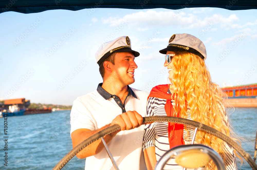 Young smiling couple on a sailing boat at summer