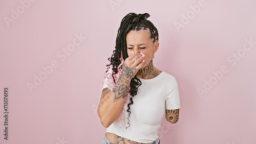 Woman amputee, hispanic standoff over stinky, intolerable stench! disgusting bad smell sends shockwaves, as she holds nose in breath-halted disgust against isolated pink background