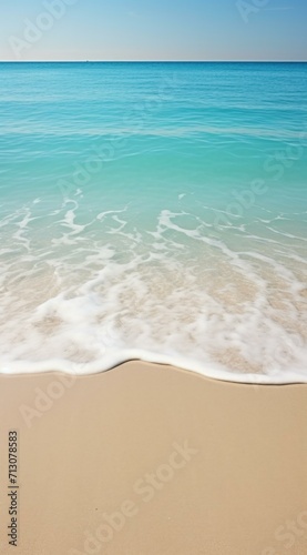 A sandy beach with waves and a blue ocean. Generative AI.