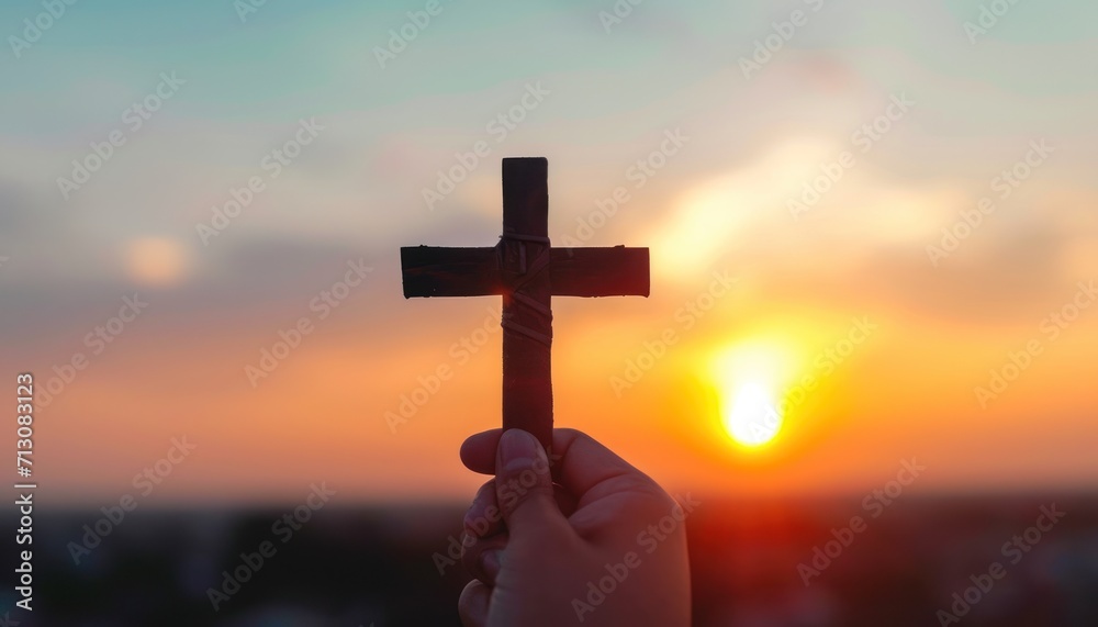 Silhouette hand holds wooden cross against a sunrise backdrop, palm sunday sunset picture