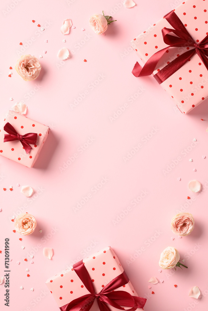 Pink gift boxes with red ribbon bow, roses flowers, confetti on pastel pink background. Happy Valentine's Day vertical background. Pink gift boxes with red ribbon bow, roses flowers, confetti on pastel pink background. Happy Valentine's Day vertical background.