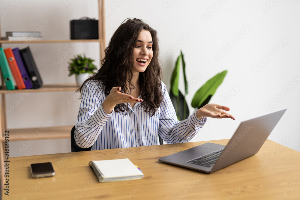 Young pretty woman having video call via laptop in the office Young pretty woman having video call via laptop in the office