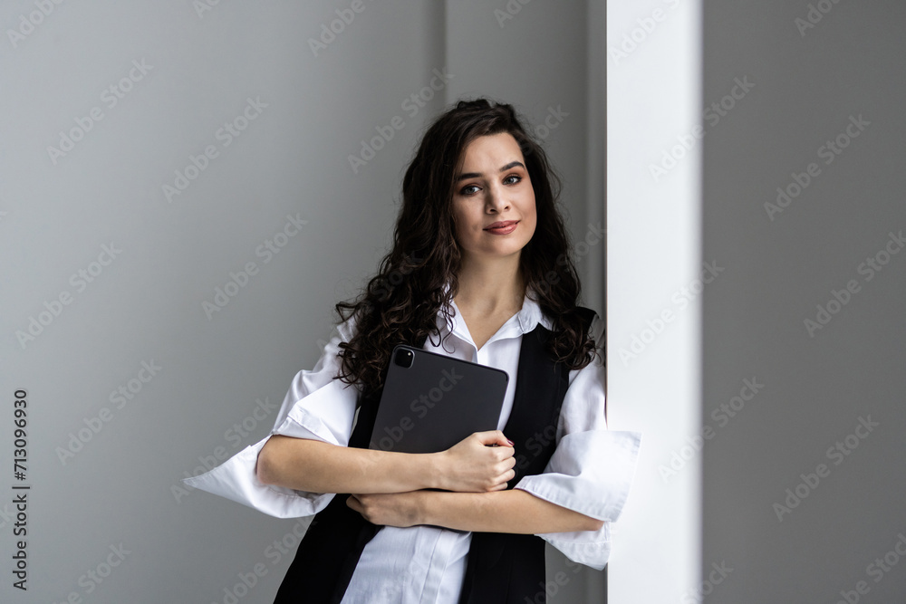 Young happy businesswoman using digital tablet while standing in the office Young happy businesswoman using digital tablet while standing in the office