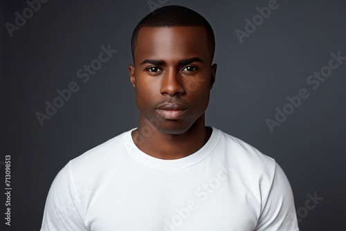 good-looking African man white casual t-shirt against gray wall with  Black History Month