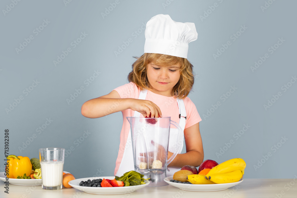 Cooking children. Chef kid boy making fresh smoothie for healthy eat. Portrait of little child in form of cook isolated on grey background. Kid chef. Cooking process. Cooking children. Chef kid boy making fresh smoothie for healthy eat. Portrait of little child in form of cook isolated on grey background. Kid chef. Cooking process.