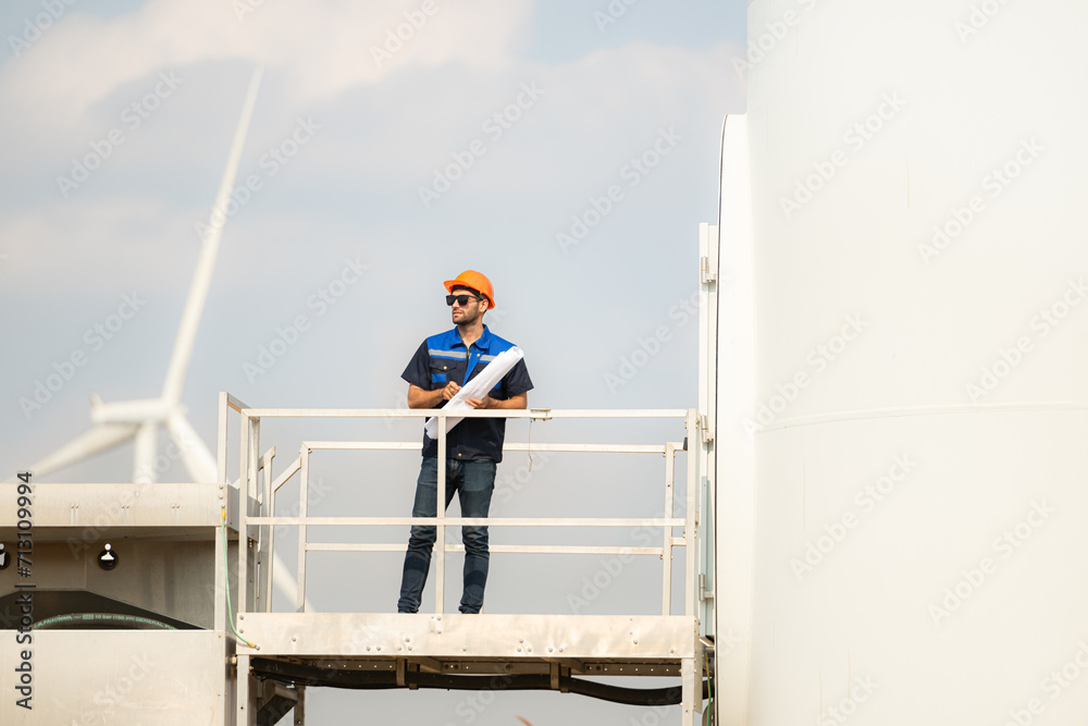 Technician checking wind turbine in wind turbine farm for maintenance. Technician checking wind turbine in wind turbine farm for maintenance.