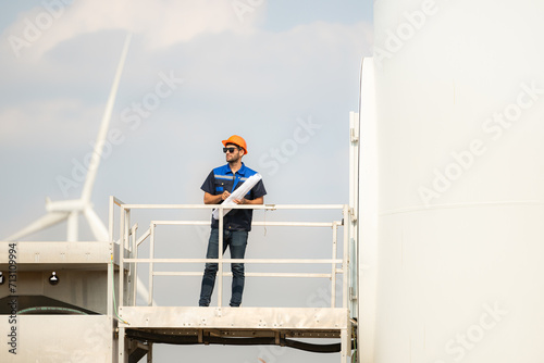Wallpaper Mural Technician checking wind turbine in wind turbine farm for maintenance. Torontodigital.ca