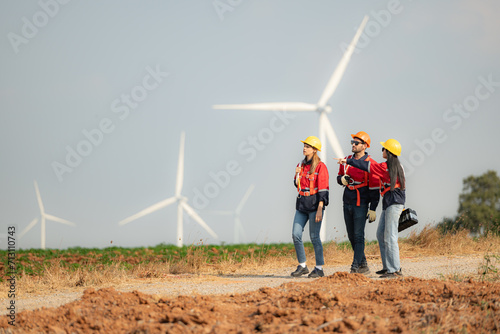 Team of engineers working on wind turbines in a wind farm