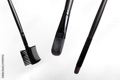 Three black makeup brushes on a white background