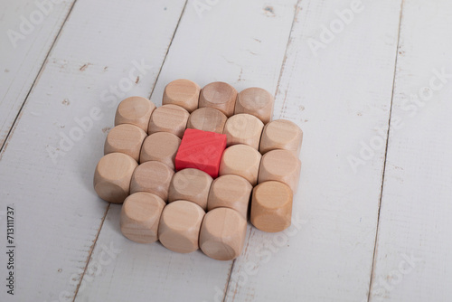 Colorless wooden squares, with a red square in the center. Difference concept