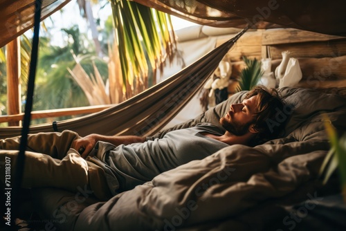 guy napping in hammock in glamping, hostel or coliving with palm trees on island resort. Digital nomad, solo traveler, tourist.  photo