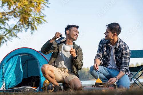Happy Asian male gay couple on camping together in a forest. romantic vocation trip. lgbt concept © Natee Meepian